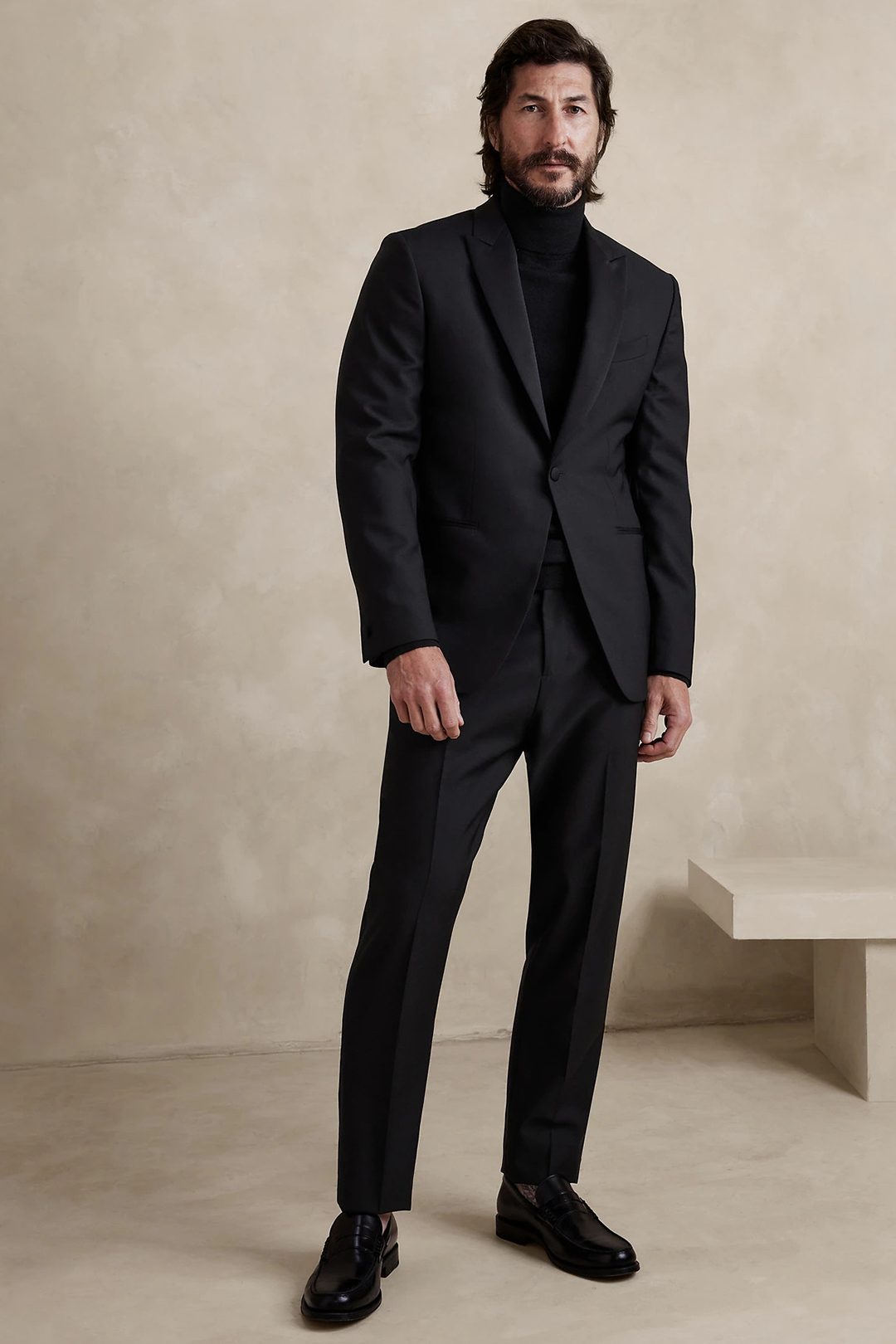 All black outfit with a suit, turtleneck, and penny loafers