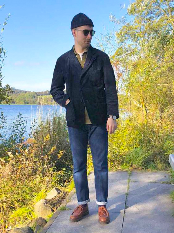 Black corduroy blazer, white crew neck t-shirt, olive polo, navy jeans, brown leather desert boots outfit