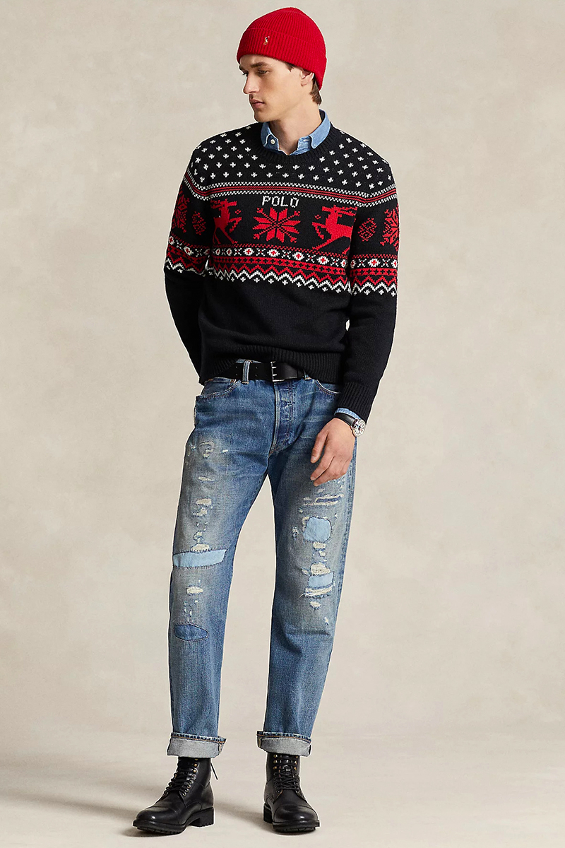 Black festive sweater, blue denim shirt, blue distressed jeans, and black casual boots outfit