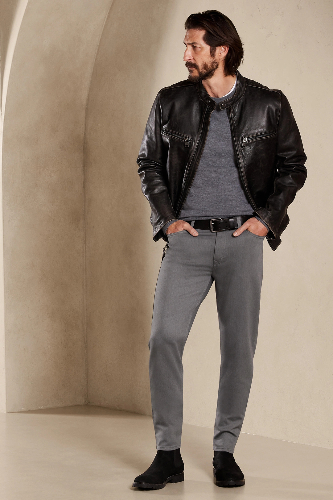 Black leather racer jacket, gray sweater, gray jeans, and black suede Chelsea boots outfit