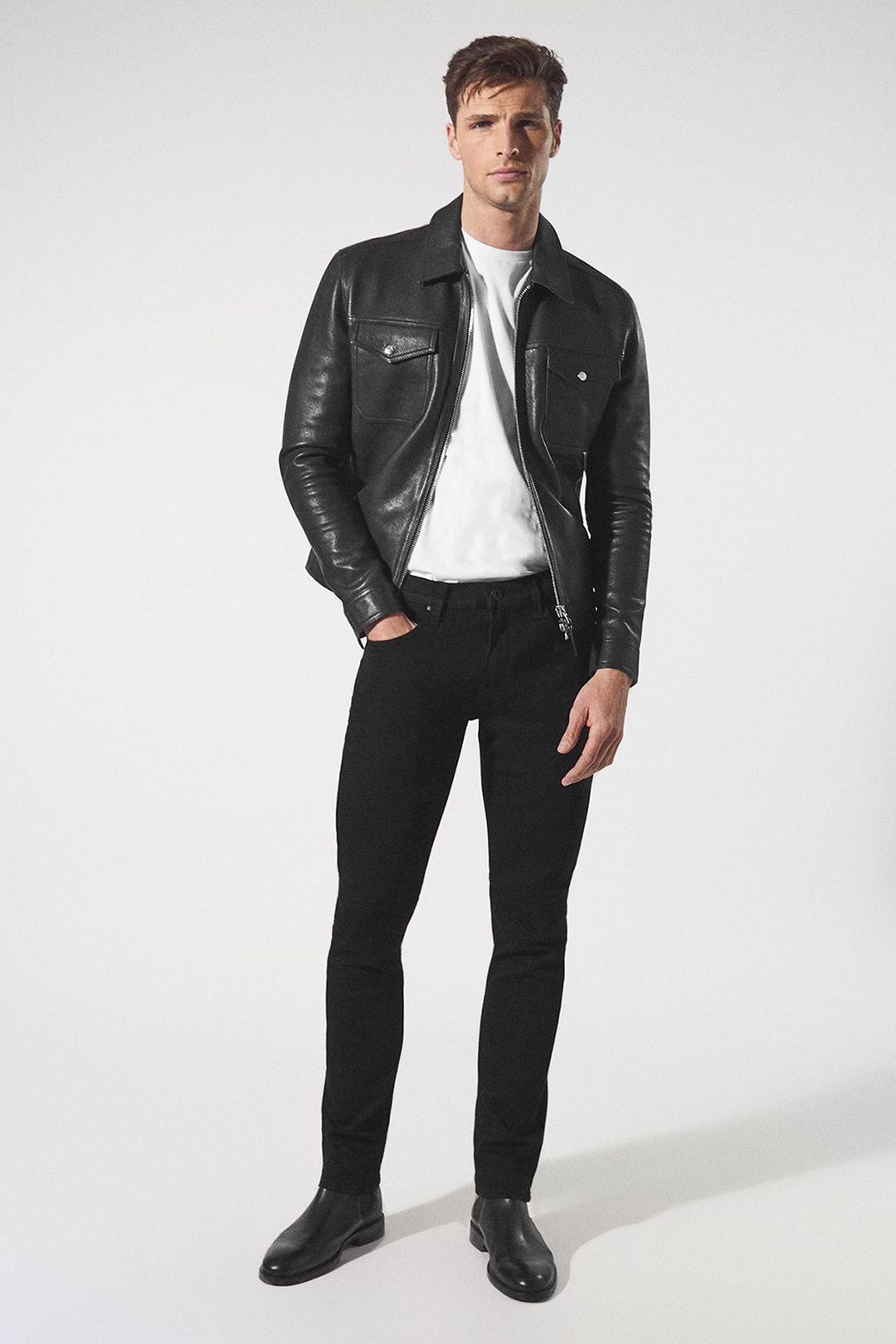 Black leather trucker jacket, white t-shirt, black skinny jeans, and black Chelsea boots outfit