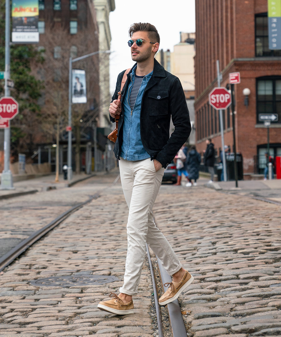 Black striped t-shirt, blue denim shirt, navy pea coat, white chinos, and tan boat shoes outfit