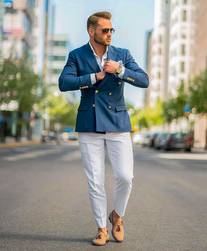 Wear a blue double-breasted jacket, white dress pants, a white shirt, and tan loafers