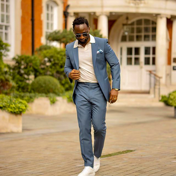 Blue suit, white polo, and low top sneakers outfit