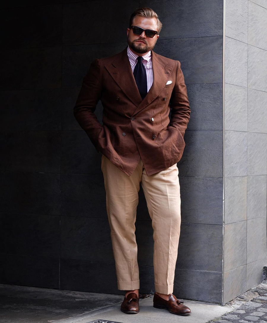 Brown double-breasted blazer, white and purple dress shirt, beige dress pants, navy tie, and brown leather tassel loafers outfit
