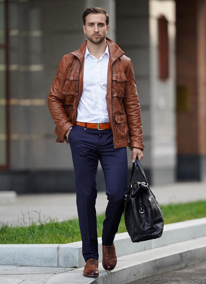 Brown leather field jacket, white dress shirt, navy blue pants, and brown leather brogues outfit