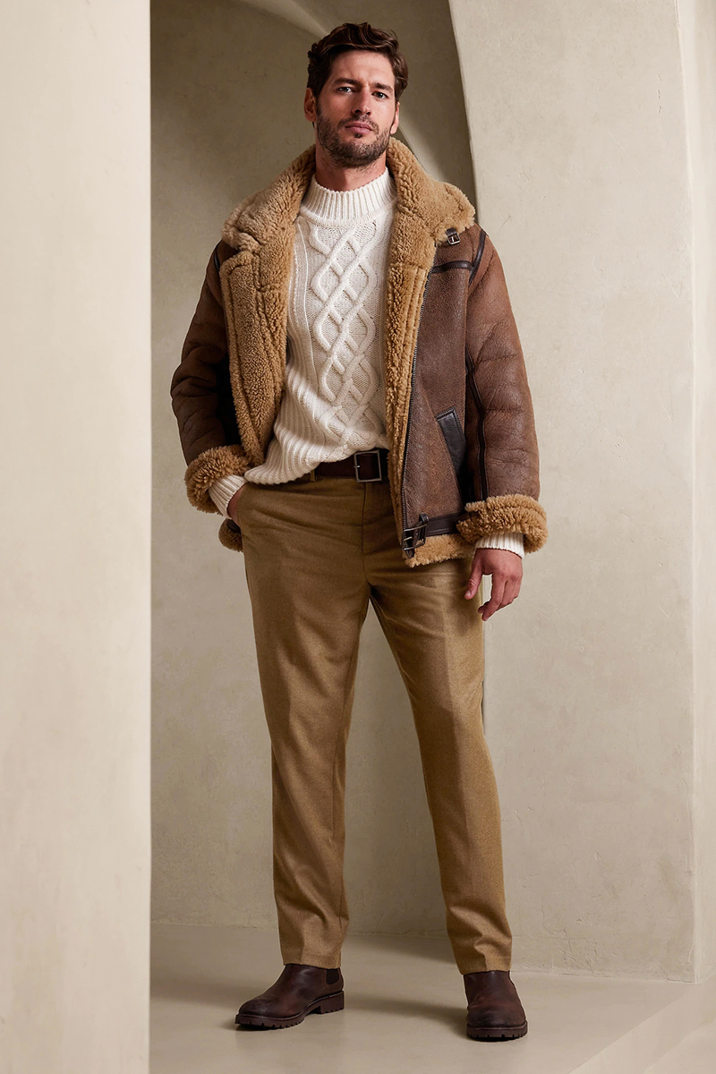 Brown shearling jacket, cable knit white sweater, khaki dress pants, and brown Chelsea boots outfit