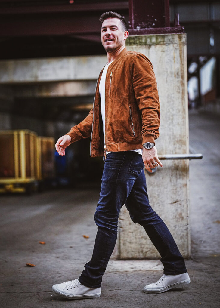Brown suede bomber jacket, white shirt, and dark blue jeans