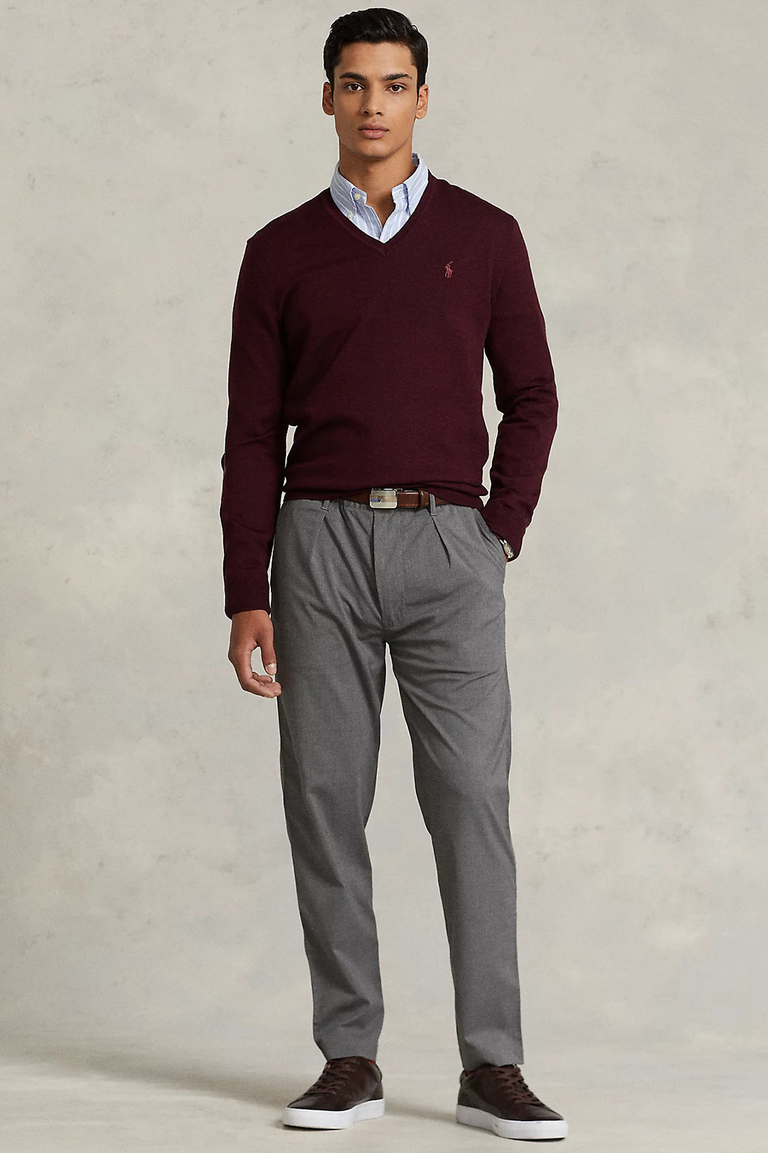 Burgundy v-neck sweater, light blue striped dress shirt, charcoal chinos, and dark brown sneakers outfit