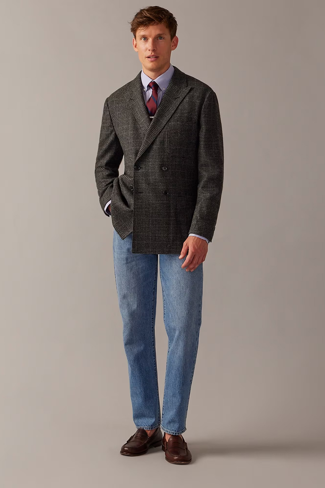 Charcoal double-breasted blazer, light blue dress shirt, burgundy striped tie, blue jeans, and dark brown loafers outfit