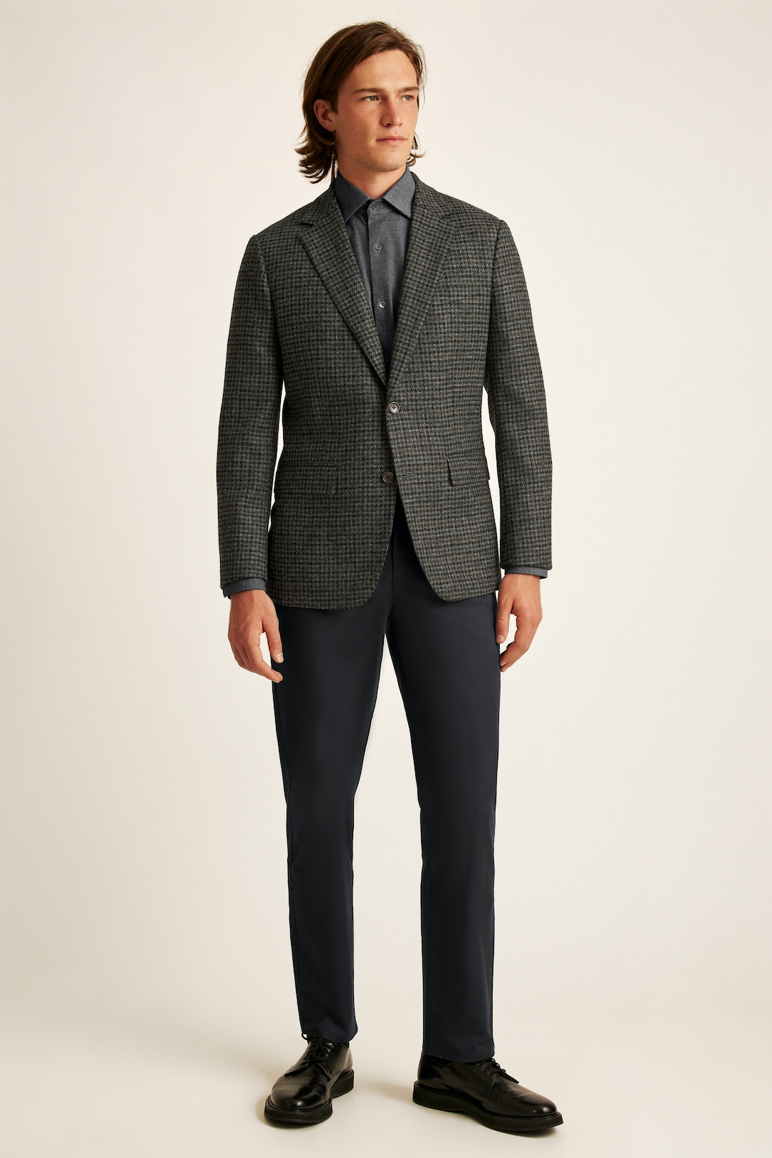 Charcoal houndstooth blazer, gray dress shirt, gray chinos, and black derby shoes outfit