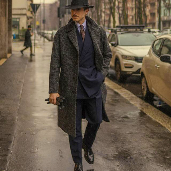 Charcoal coat, navy suit, light blue dress shirt, and black derby shoes outfit