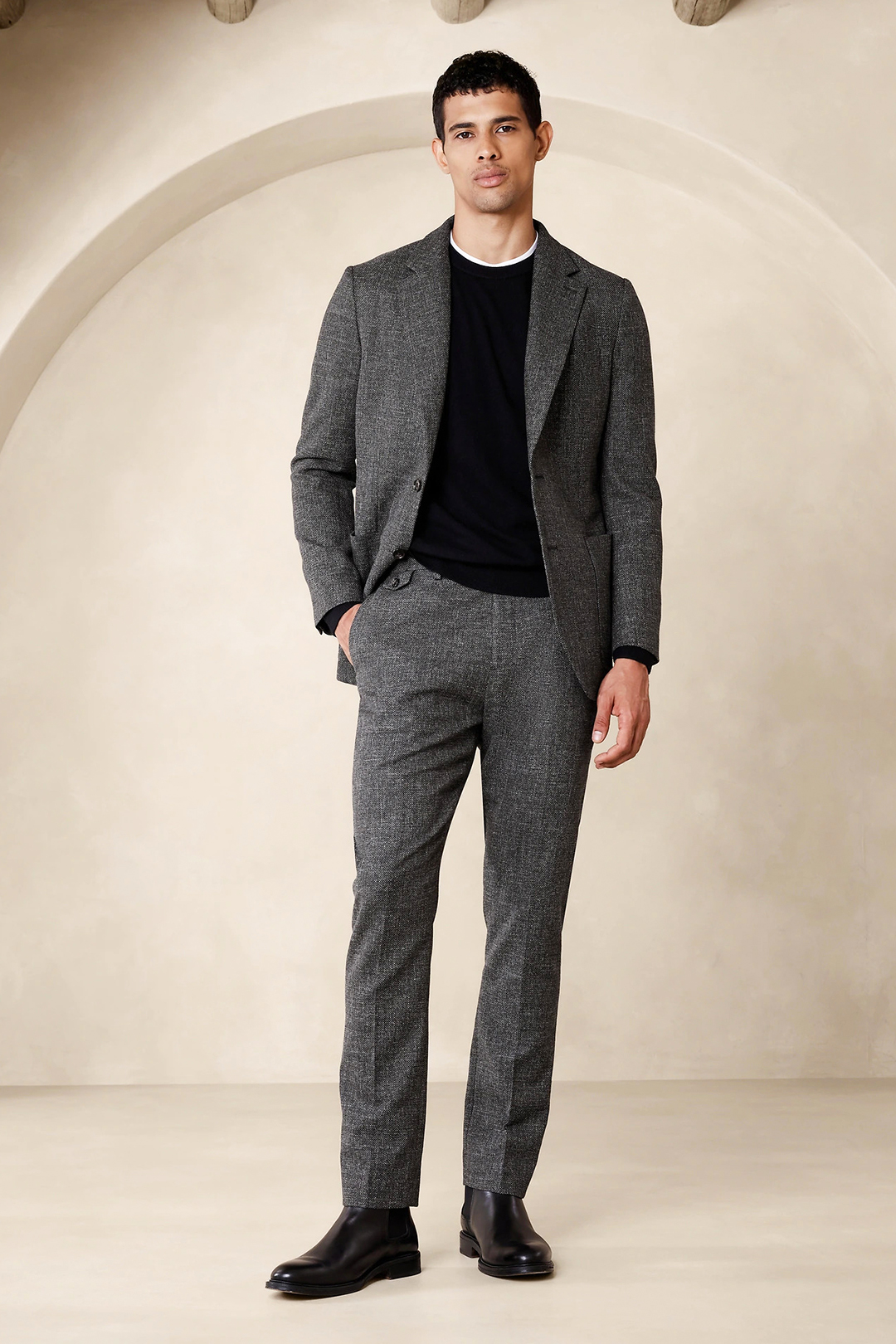 Charcoal suit, black crew neck sweater, and black Chelsea boots outfit