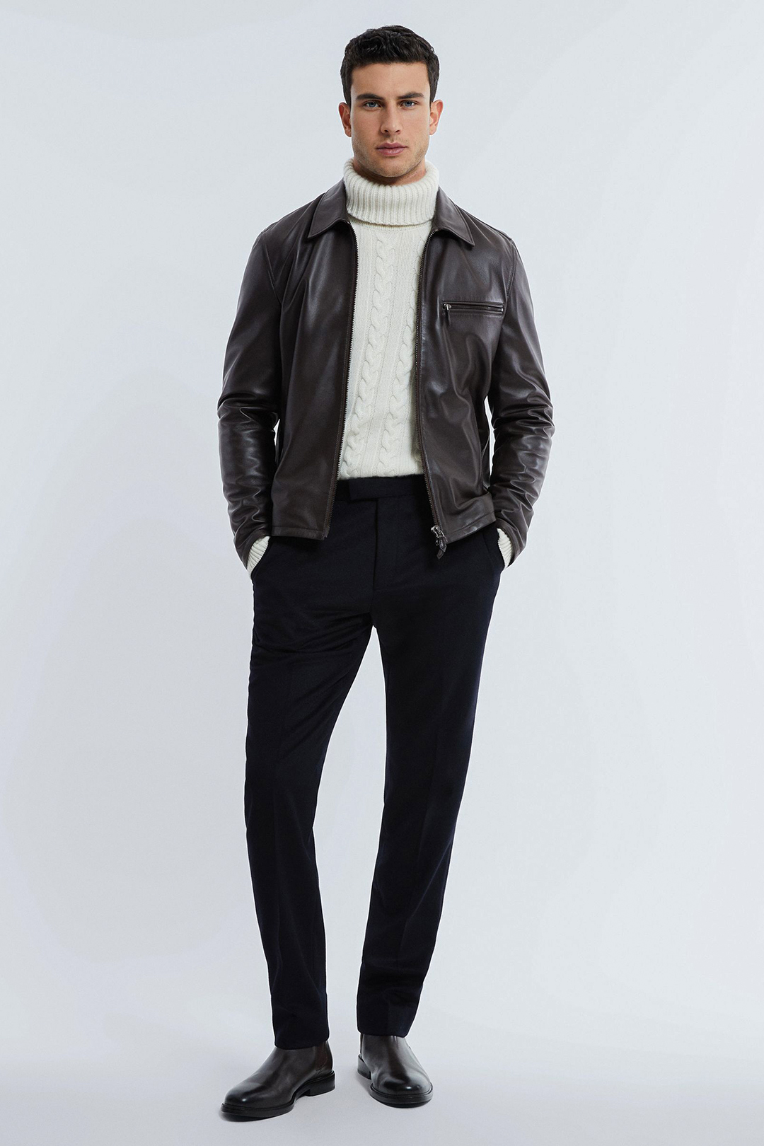 Dark brown leather foster jacket, white turtleneck, black dress pants, and brown Chelsea boots outfit