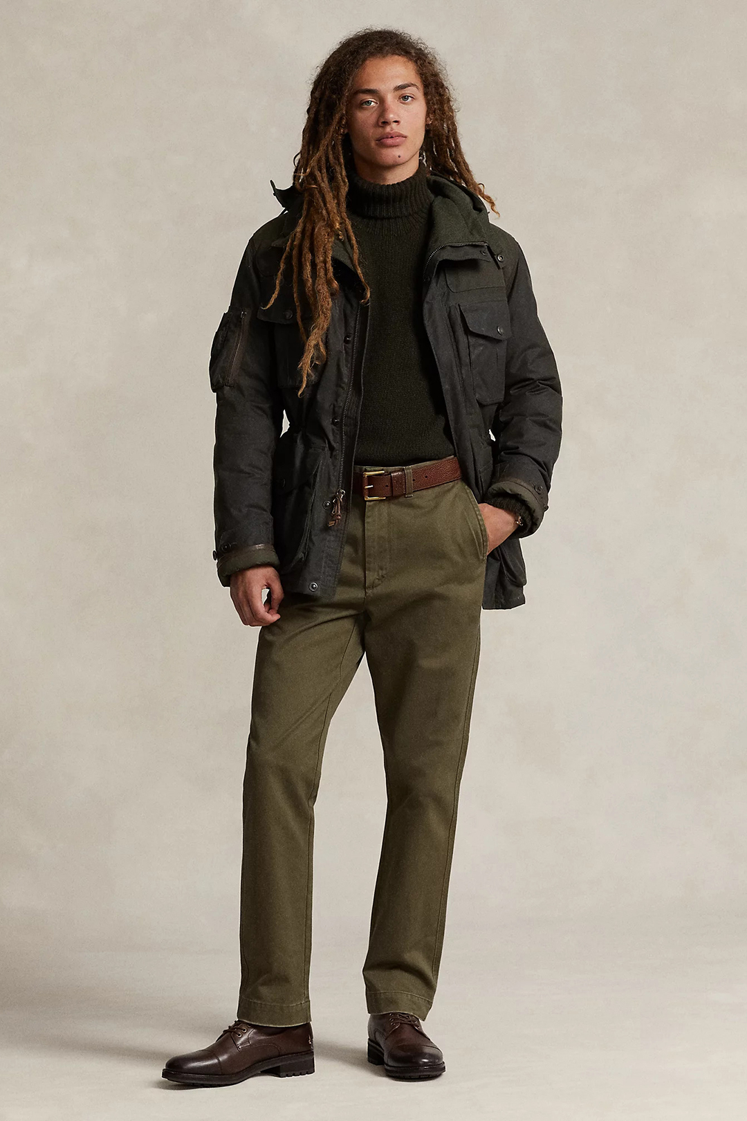 Dark green jacket, green turtleneck, olive chinos, and brown derby shoes outfit