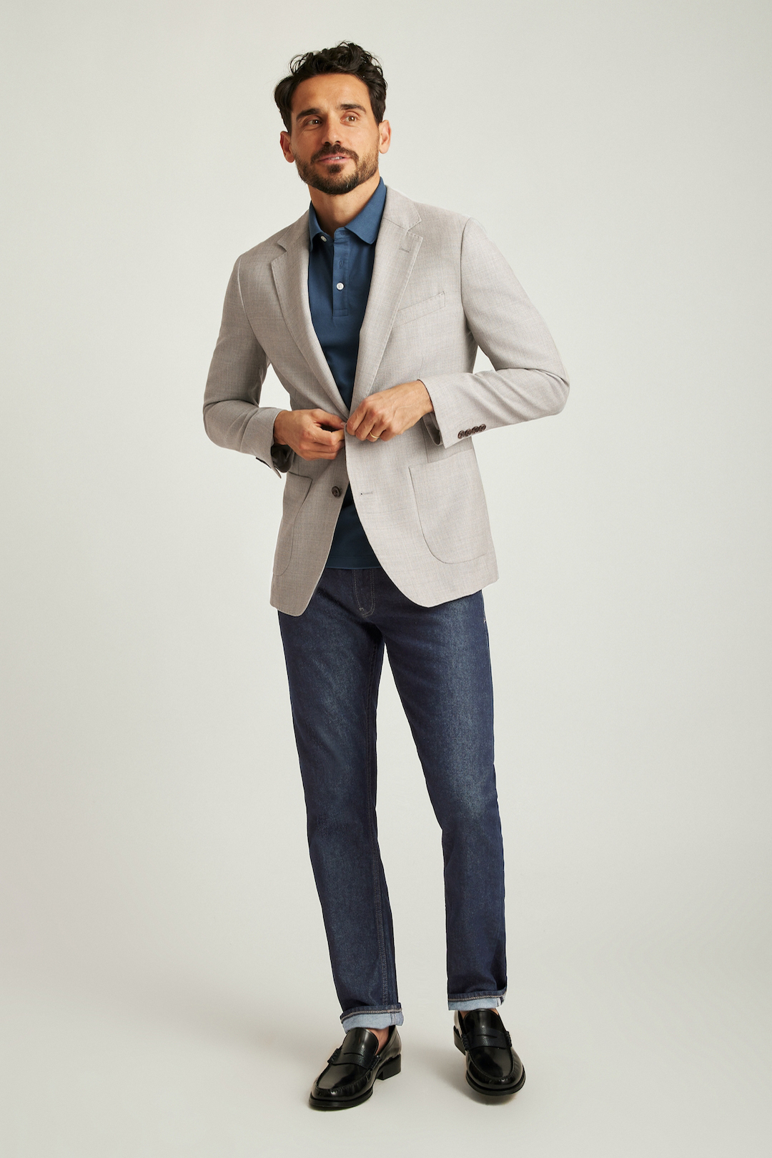 Gray blazer, blue polo t-shirt, navy denim jeans, and black penny loafers outfit
