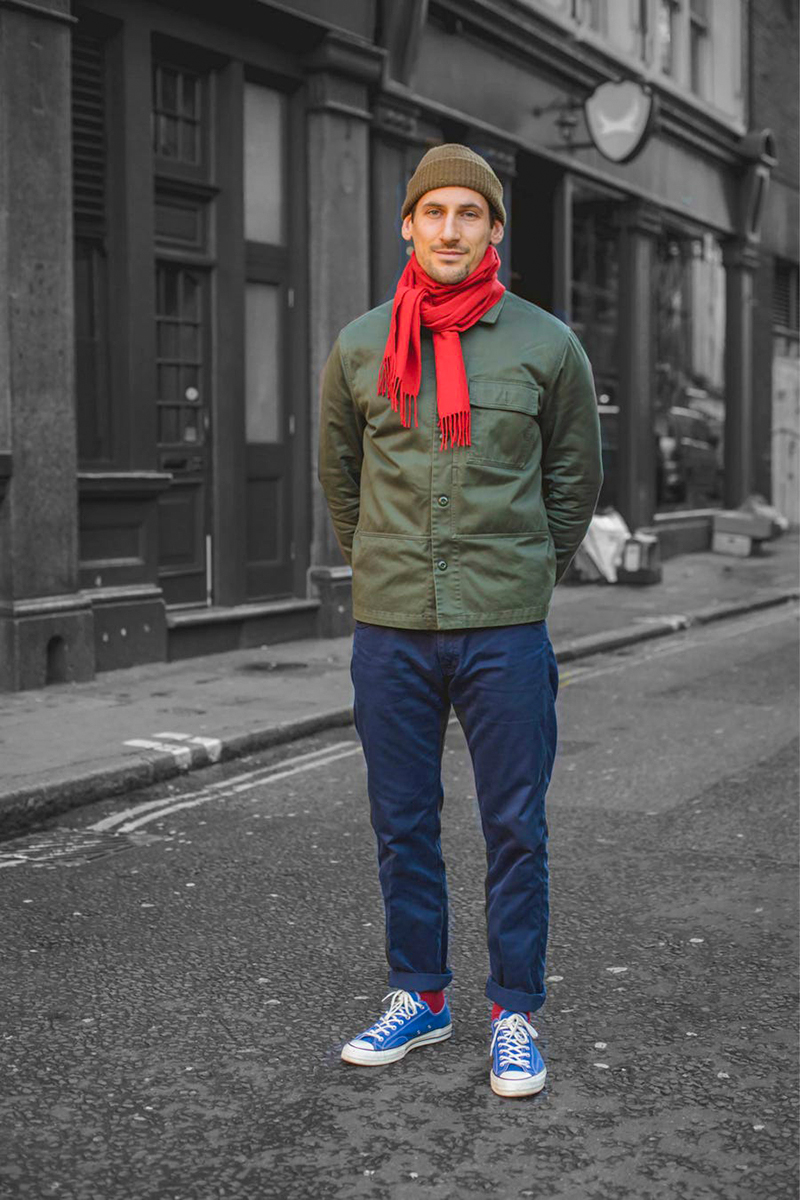 Green field jacket, blue chinos, red scarf, green beanie, blue converse shoes outfit