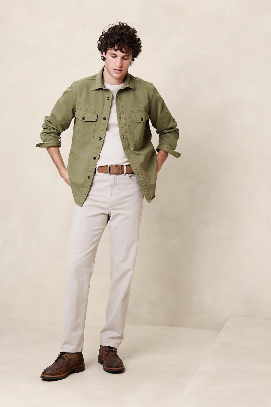 Green overshirt, beige t-shirt, cream jeans, and casual boots outfit