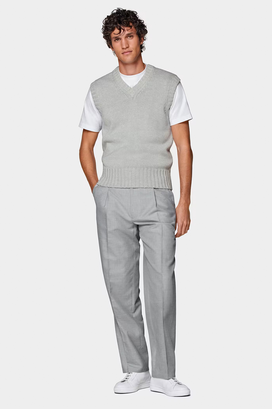 Grey sweater vest, white t-shirt, grey dress pants and white sneakers outfit