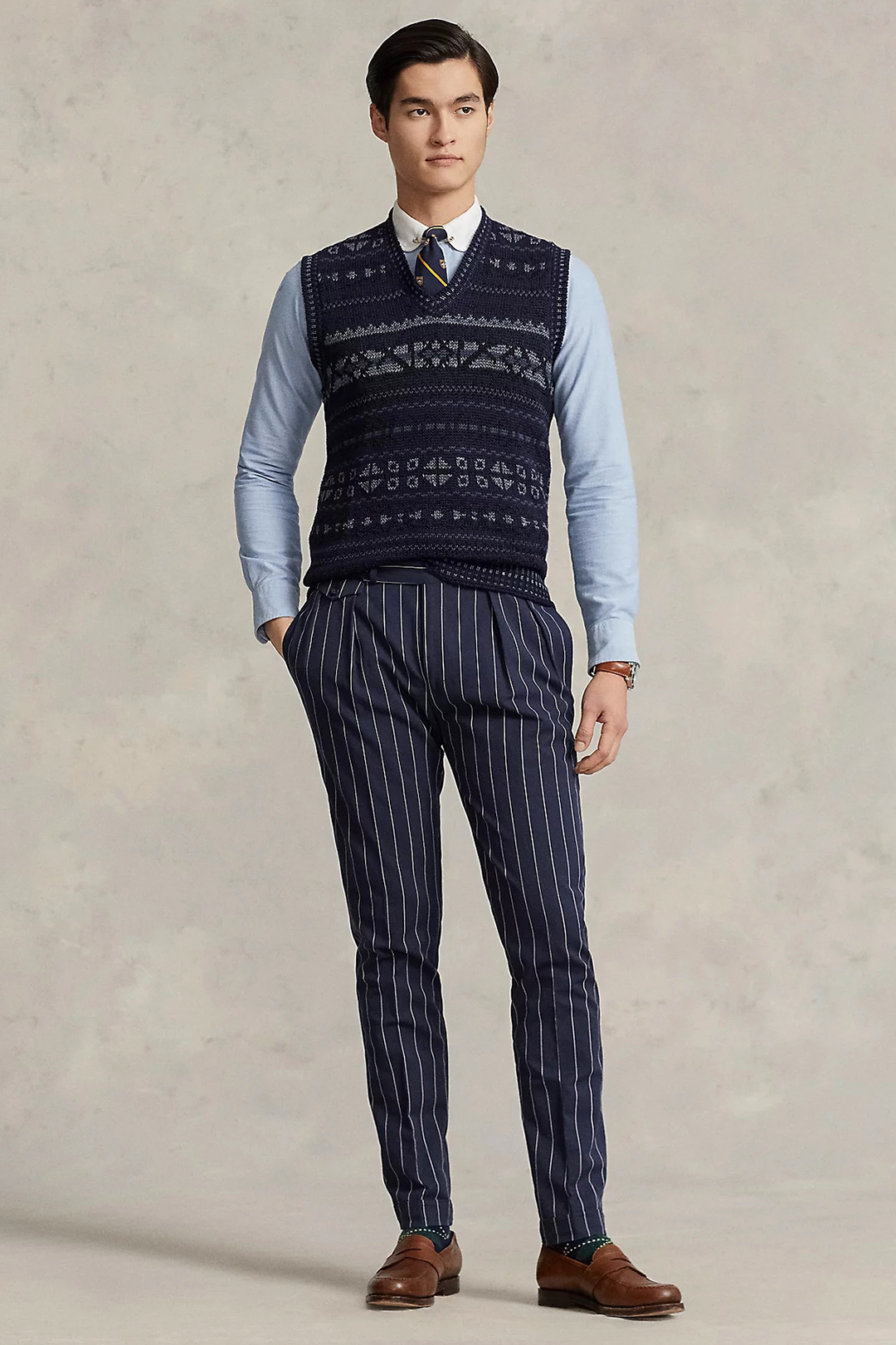 Navy fair isle sweater vest, blue shirt, striped silk club tie, navy dress pants and brown penny loafers outfit