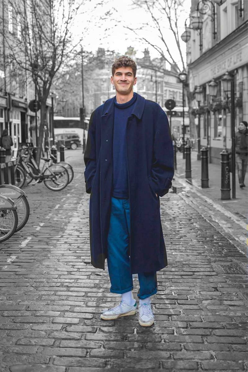 Navy overcoat, blue jumper, blue chinos, white low-top sneakers outfit
