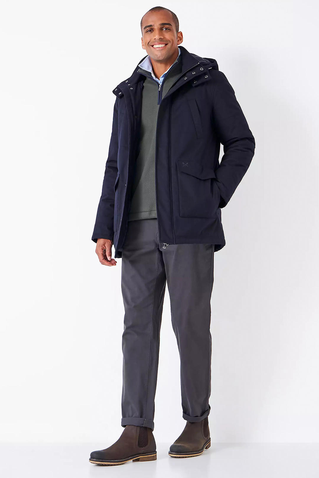 Navy parka jacket, olive sweater, light blue dress shirt, charcoal chinos, and brown suede Chelsea boots outfit