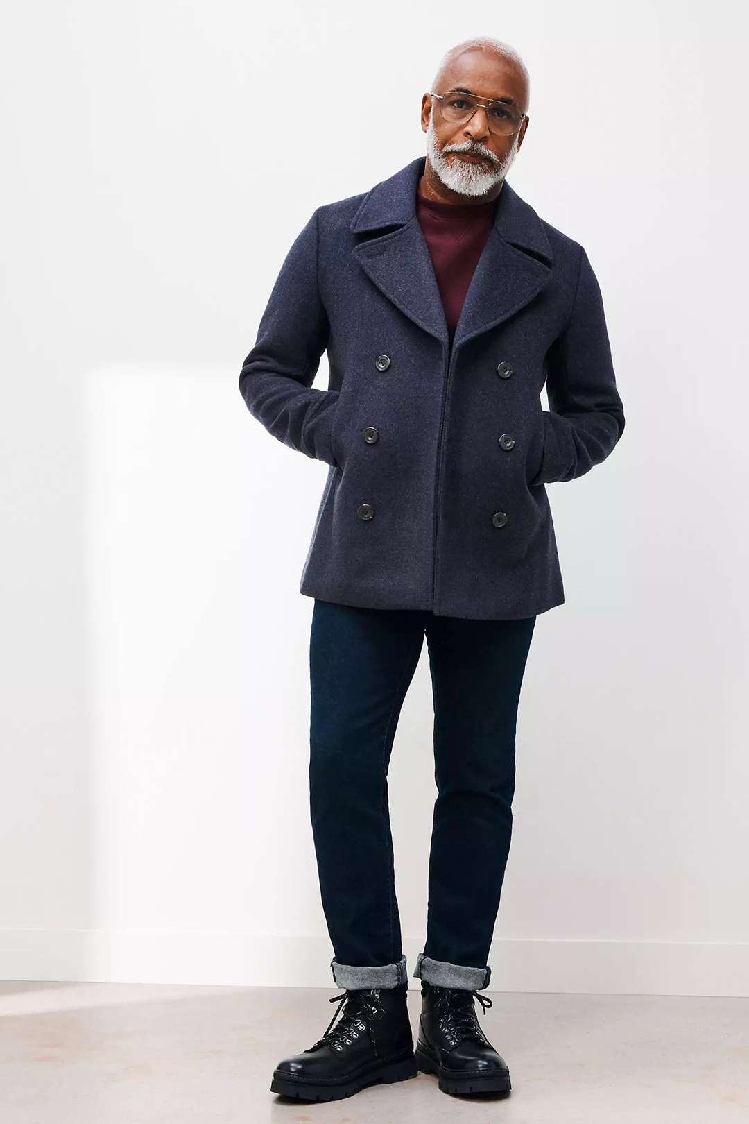 Navy pea coat, burgundy crew neck sweater, navy denim jeans, and black casual boots outfit