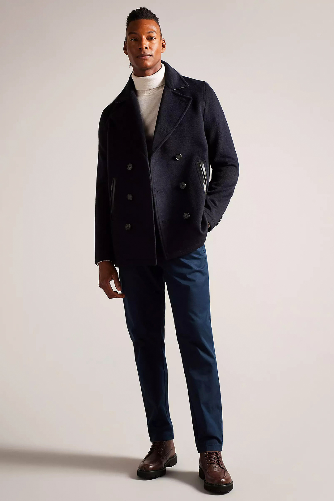 Navy pea coat, white turtleneck, blue dress pants, and brown lace up boots outfit