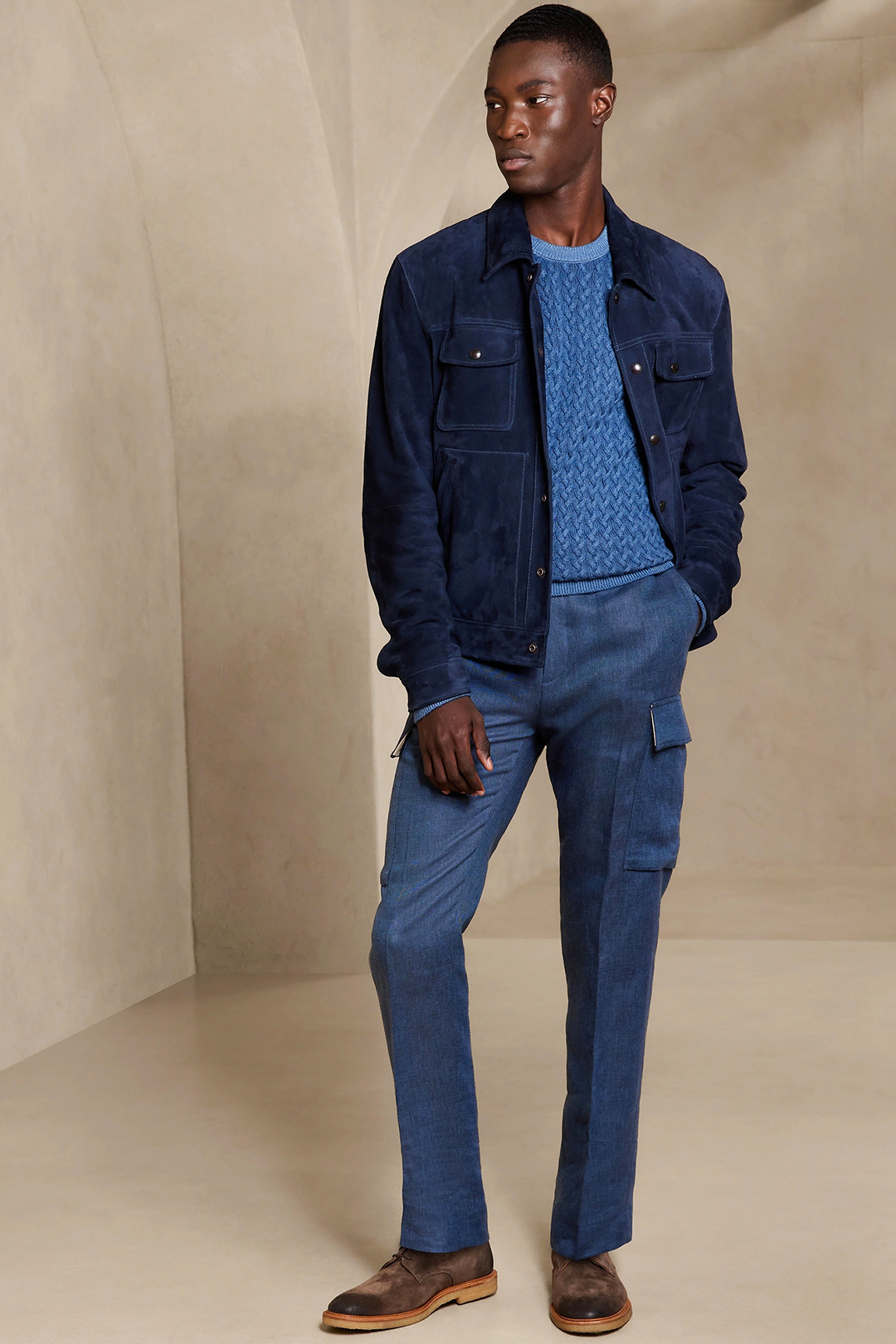Navy suede shirt jacket, blue sweater, blue cargo pants, and brown derby shoes outfit