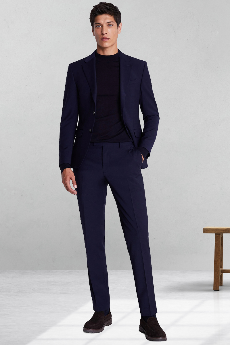 Navy suit, black crew neck sweater, and dark brown suede loafers outfit