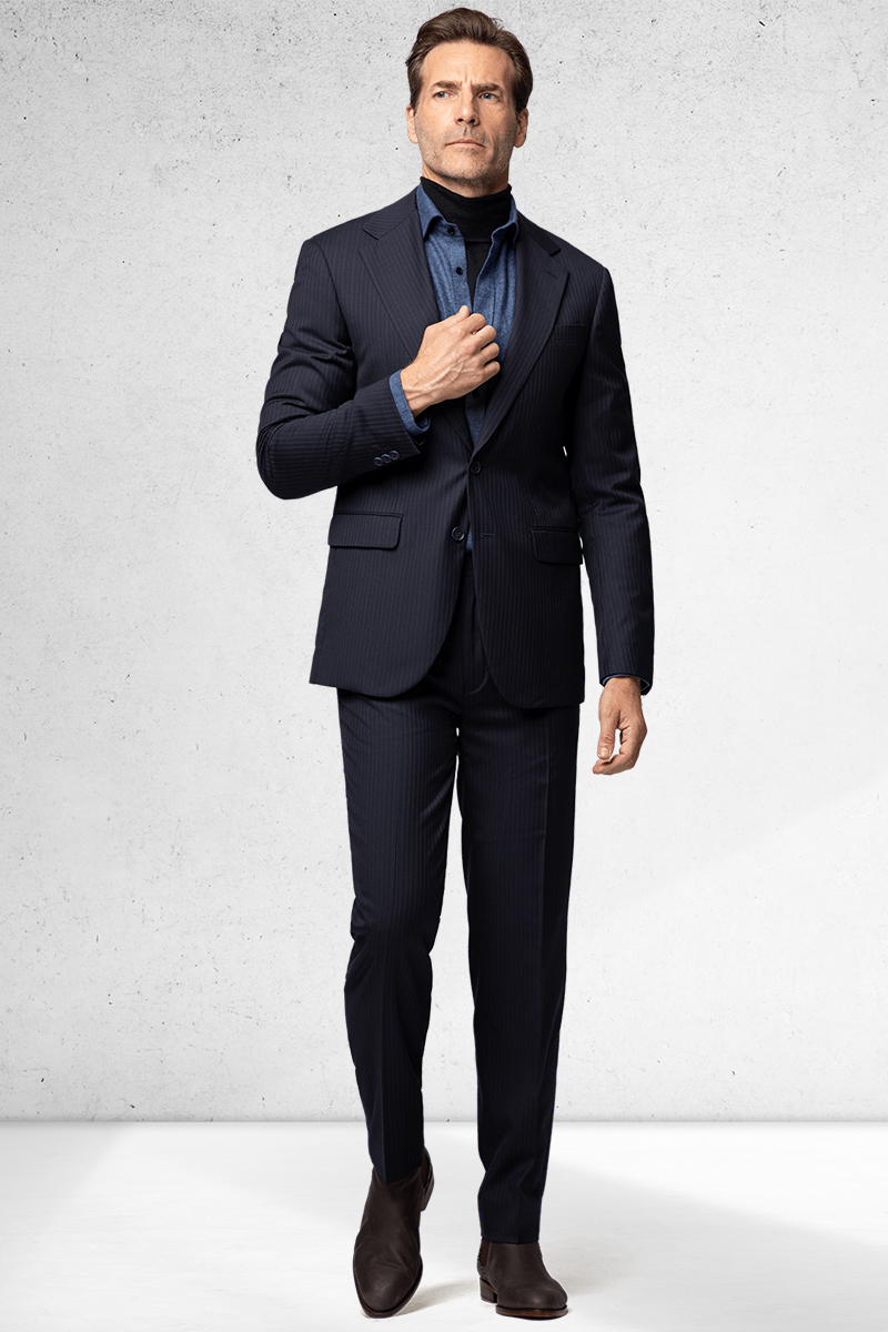 Navy suit, blue denim shirt, black turtleneck, and dark brown suede Chelsea boots outfit