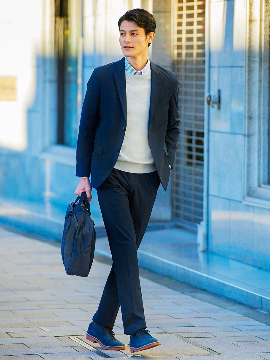 Navy suit, gray crew neck sweater, dress shirt, and brogues outfit