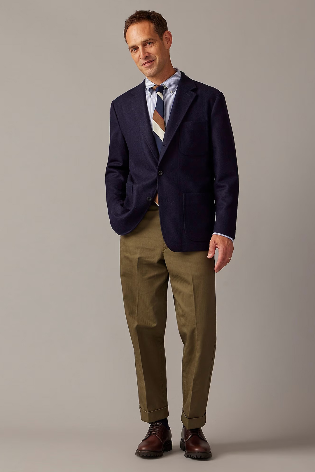 Navy suit jacket, blue striped button-down shirt, multi-color tie, green chinos, and dark brown derby shoes outfit