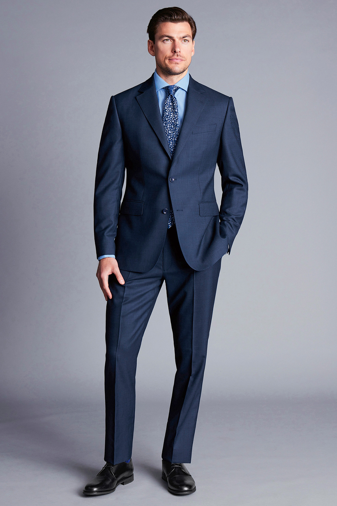 Navy suit, light blue dress shirt, blue dotted tie, and black derby shoes outfit