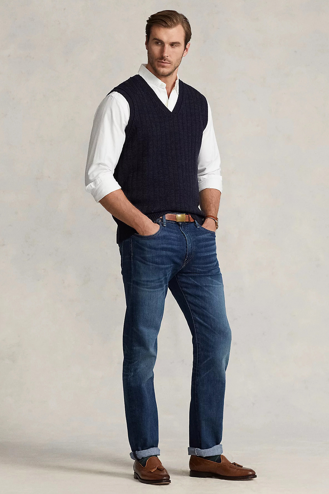 Navy sweater vest, white dress shirt, navy denim jeans and brown loafers outfit