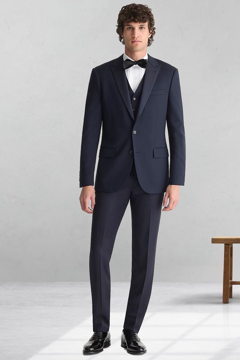 Navy three-piece tuxedo, white tuxedo shirt, black bow tie, and black polished leather oxford shoes outfit