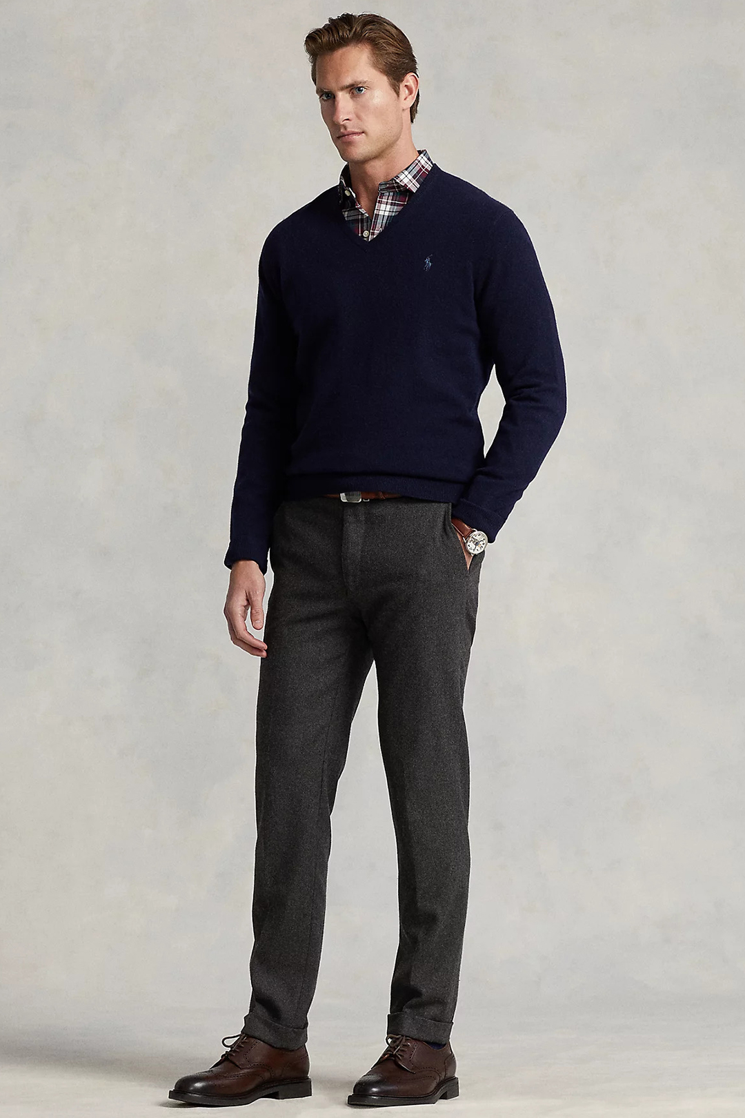Navy v-neck sweater, multi-color shirt, gray dress pants, and brown derby brogues outfit