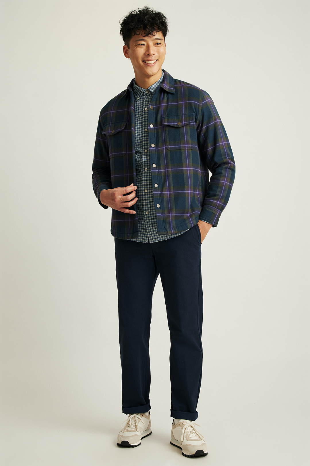 Navy violet plaid overshirt, white and blue button-down shirt, navy chinos, and beige sneakers outfit