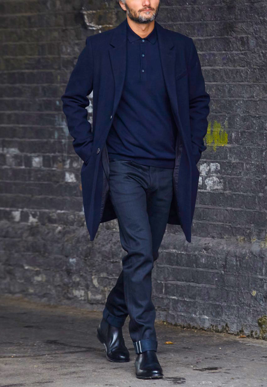 Navy overcoat with navy long-sleeve polo shirt, black chinos, and black Chelsea boots outfit