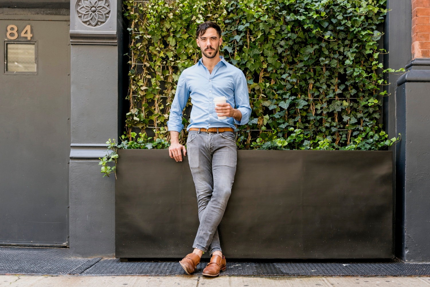 Stylish model wearing gray jeans and brown monk straps