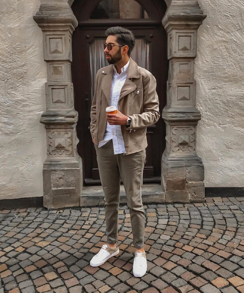Tan biker jacket, white shirt, olive jeans, and white sneakers