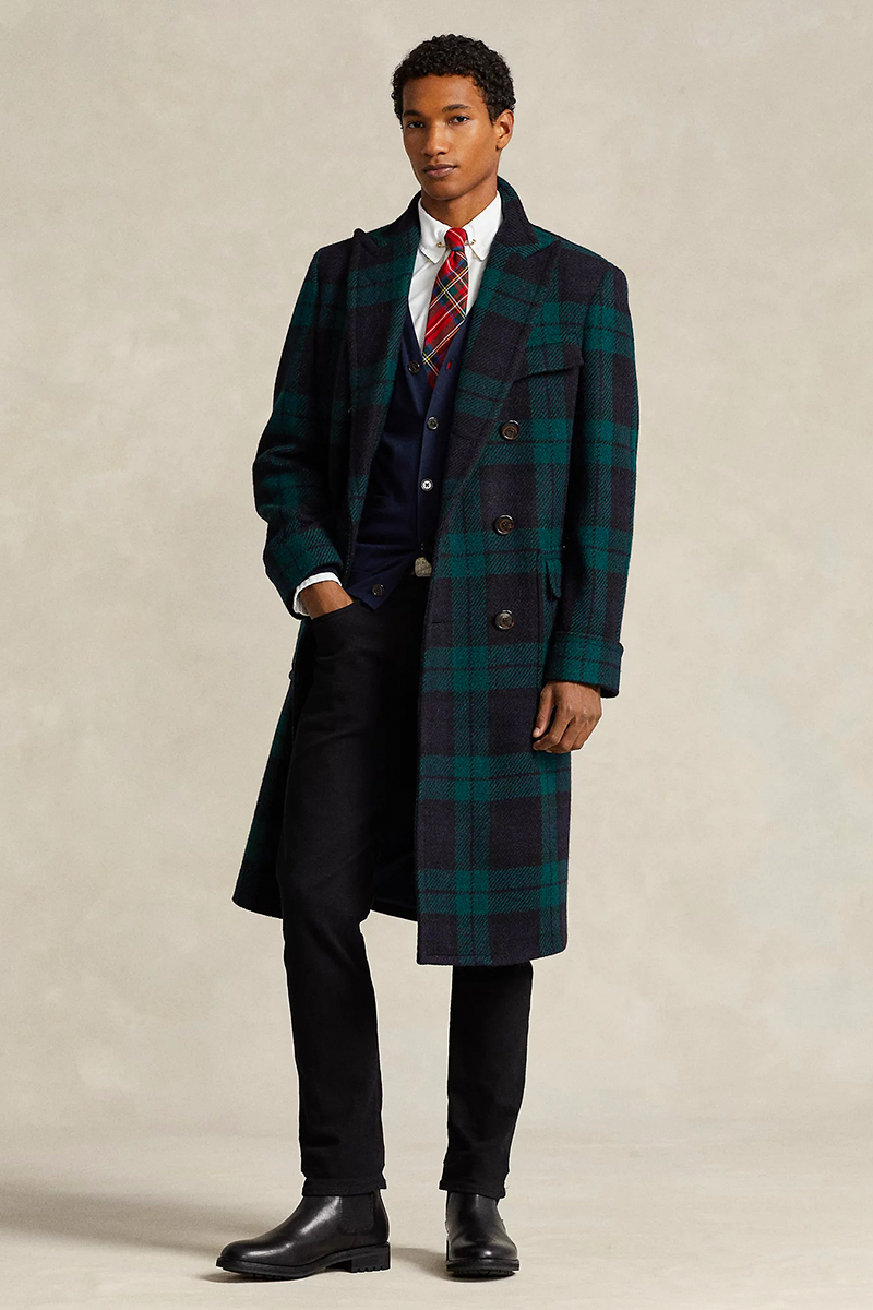 Tartan plaid overcoat, navy blazer, white dress shirt, red tartan tie, black dress pants, and black leather Chelsea boots outfit