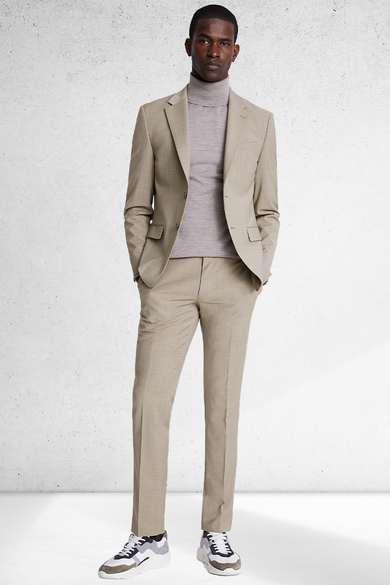 Taupe suit, taupe turtleneck, and gray and khaki trainers outfit