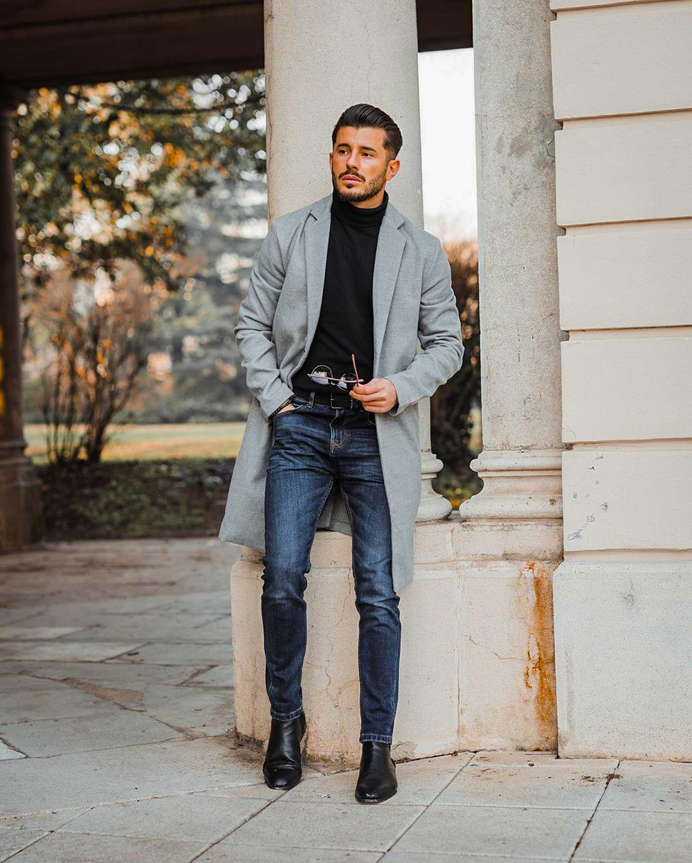 Gray overcoat, black turtleneck, navy denim jeans, and black Chelsea boots outfit