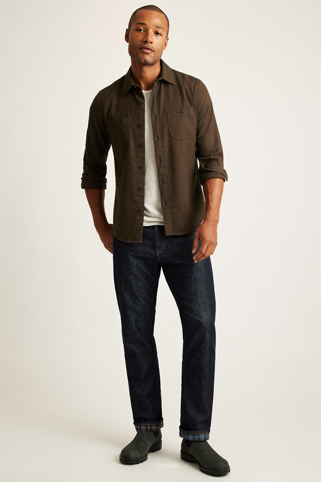 Wear brown shirt jacket, white t-shirt, navy denim jeans, and olive Chelsea boots