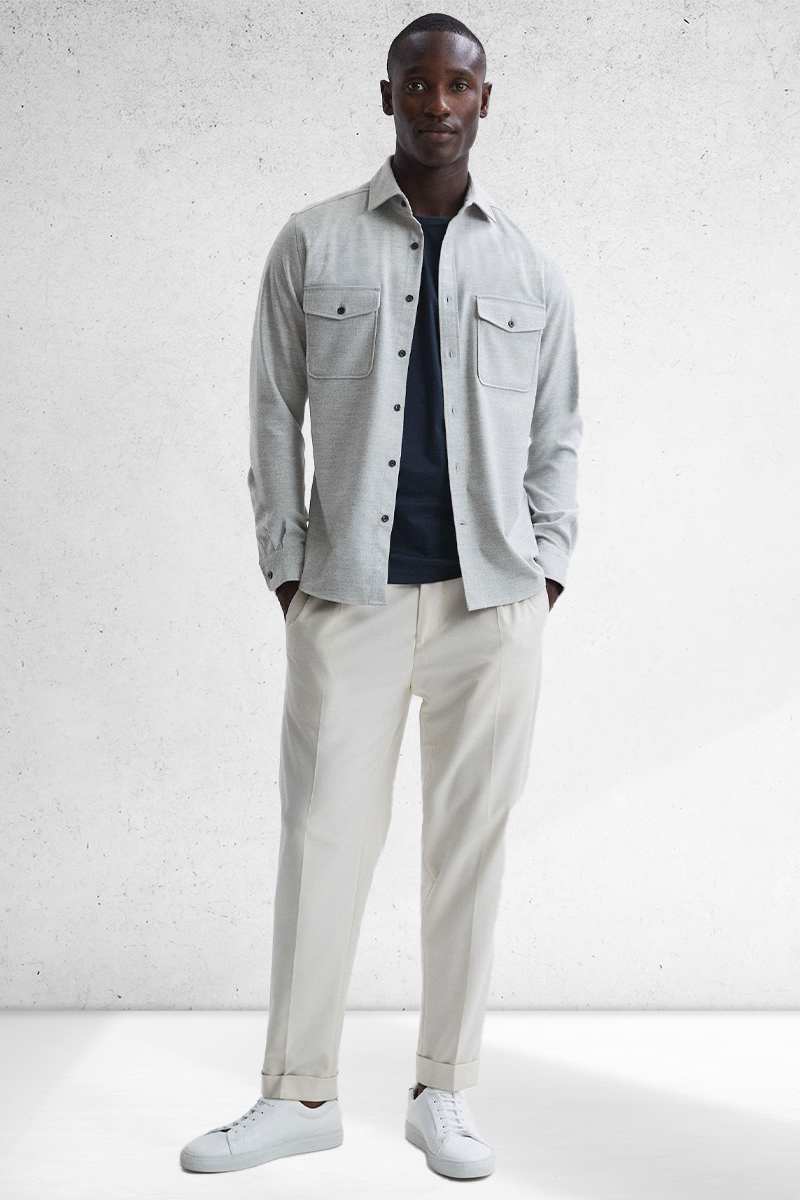 Wear a gray overshirt, navy crew neck t-shirt, off white drawstring trousers, and white sneakers
