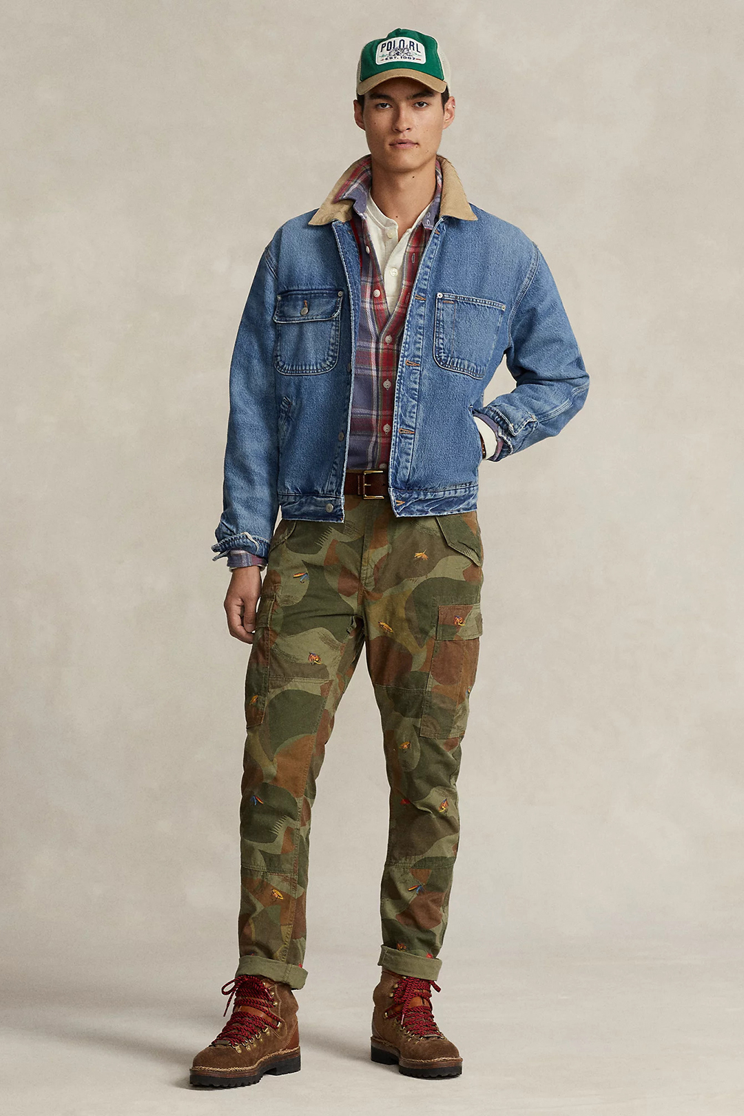 Wear a light blue denim jacket, red and blue plaid shirt, olive green camo pants, and brown sturdy boots
