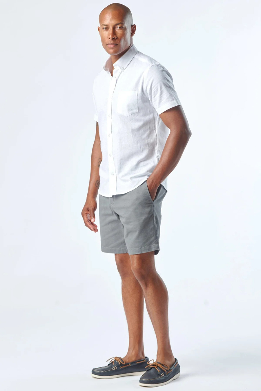 Wear a white button-down shirt, gray chinos, and navy boat shoes