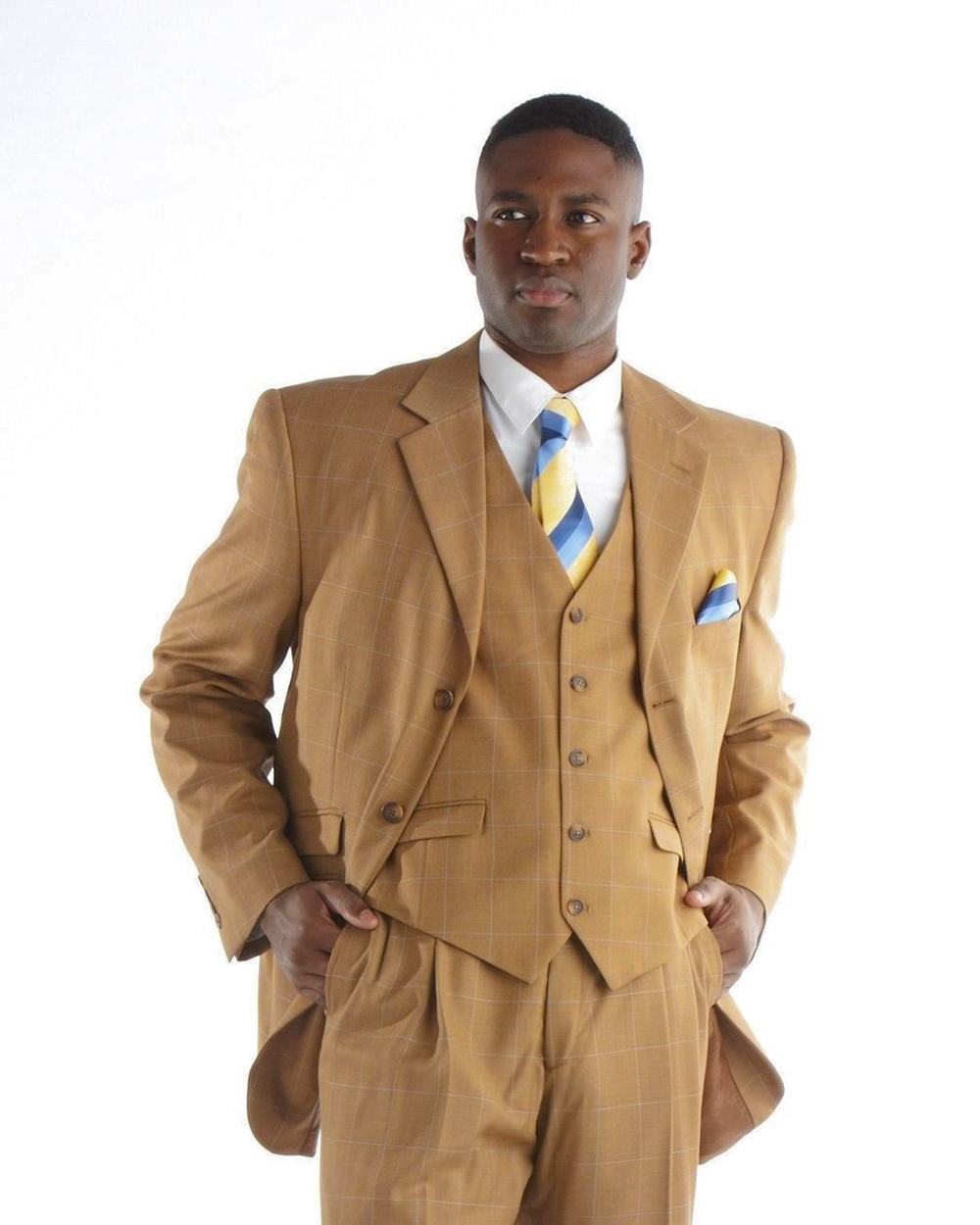 Wearing a cognac three-piece suit, white dress shirt and yellow/blue tie