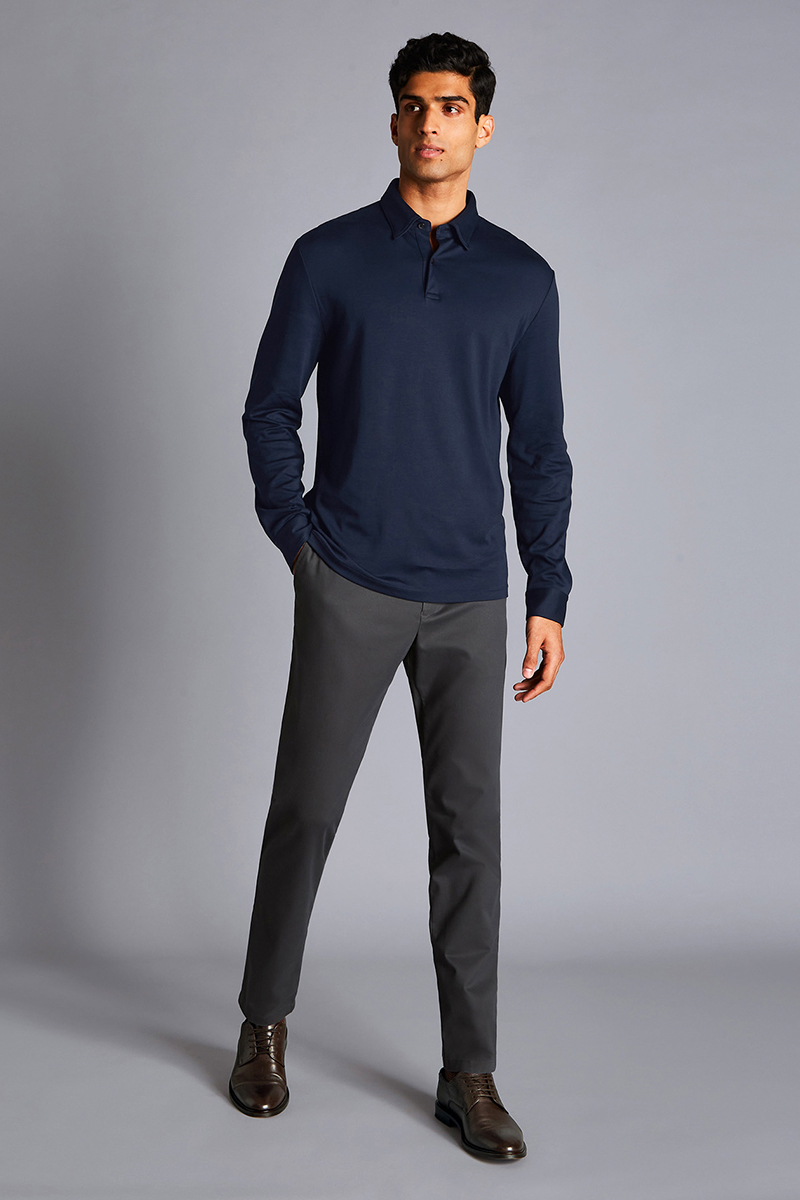Wearing a navy long sleeve polo shirt, gray chinos, and dark brown derby shoes